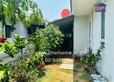 Well-maintained home exterior with lush garden and carport
