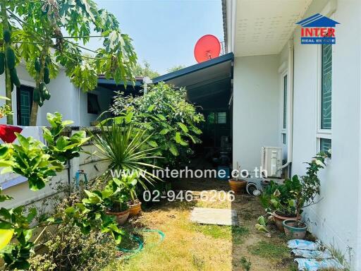 Well-maintained home exterior with lush garden and carport