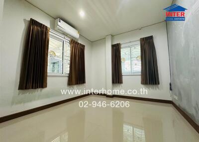 Spacious and well-lit living room with modern air conditioning and elegant window treatments