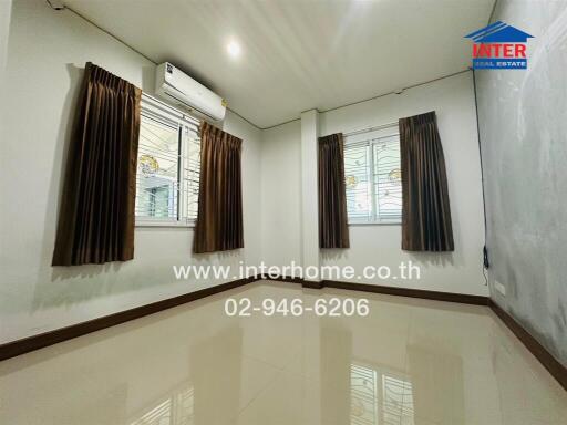Spacious and well-lit living room with modern air conditioning and elegant window treatments