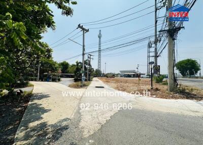 View of the property approach with paved road and surrounding infrastructure