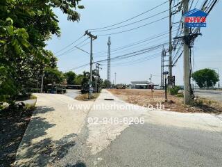 View of the property approach with paved road and surrounding infrastructure