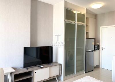 Modern compact living room with kitchenette, sliding glass door wardrobe, and minimalistic design