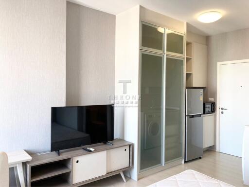 Modern compact living room with kitchenette, sliding glass door wardrobe, and minimalistic design