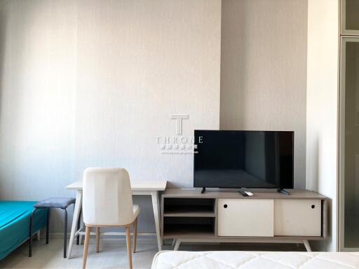 Modern minimalist living room with television and desk area