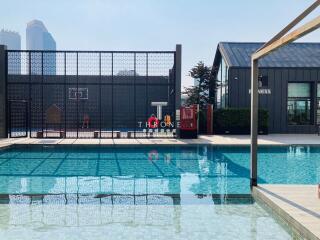 Modern outdoor pool with adjacent buildings and basketball court