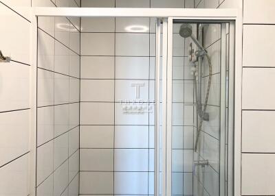 Modern, clean bathroom with glass shower doors and white tiles