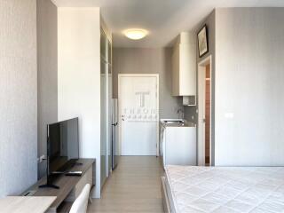 Modern bedroom with integrated living space, featuring minimalist design and neutral tones