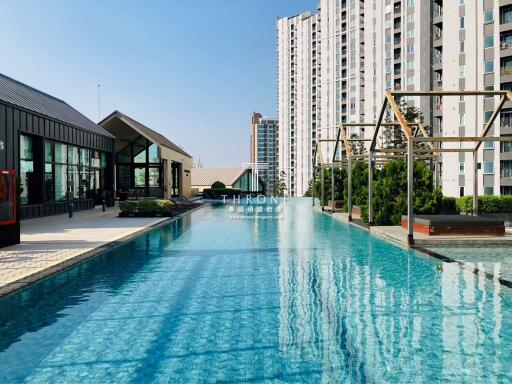 Luxurious swimming pool area with residential buildings in the background