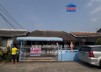 Exterior view of a gated single-story residential home with a car parked outside