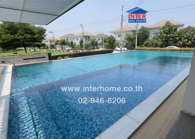 Luxurious pool area with a shaded pavilion and residential buildings in the background