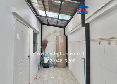 Narrow corridor or storage space in a property featuring storage cabinets and tiled flooring