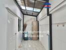 Narrow corridor or storage space in a property featuring storage cabinets and tiled flooring