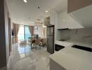 Modern kitchen with dining area showcasing a glossy marble floor, stainless steel appliances, and a scenic window view