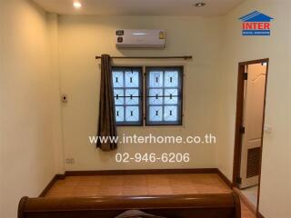 Clean and well-maintained bedroom with large window and air conditioning unit