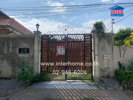 Exterior view of a residential property with a gated entrance