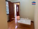 Spacious bedroom with wooden door and floor, featuring minimalistic white table