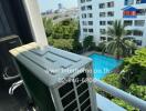 View from balcony showcasing air conditioning unit, swimming pool, and other buildings