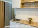 Modern kitchenette with wooden shelves and white cabinets