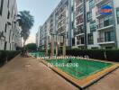 Modern apartment complex with outdoor amenities including green space and seating area