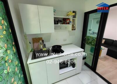 Compact modern kitchen with integrated appliances and direct view into living area