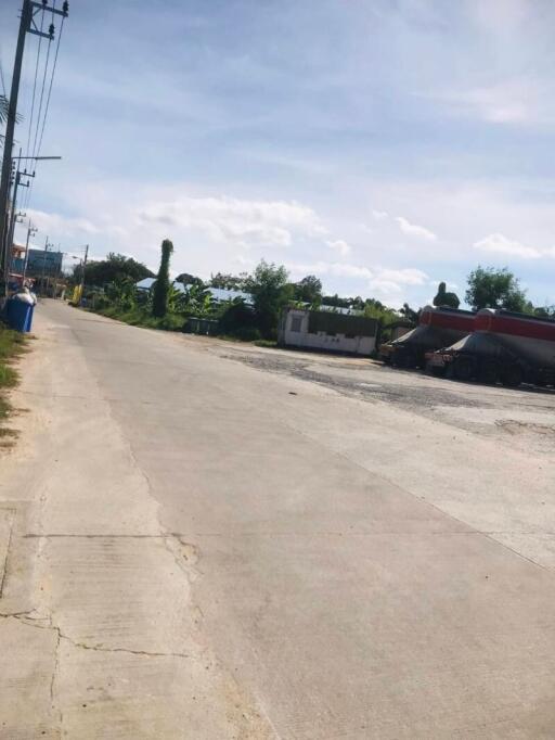 Outdoor street view near property showing paving and surrounding greenery