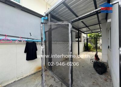 Covered outdoor area with storage and utility space in a residential property