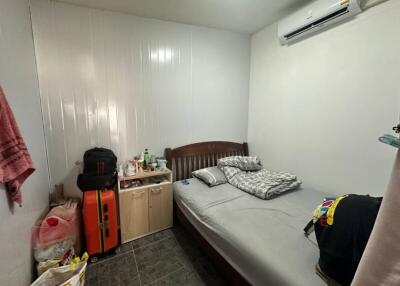 Compact bedroom with single bed and air conditioning unit