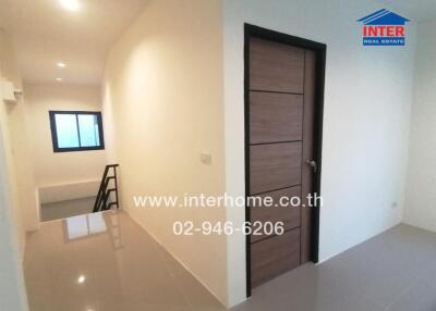 Spacious and well-lit empty bedroom with wooden door and tiled floor