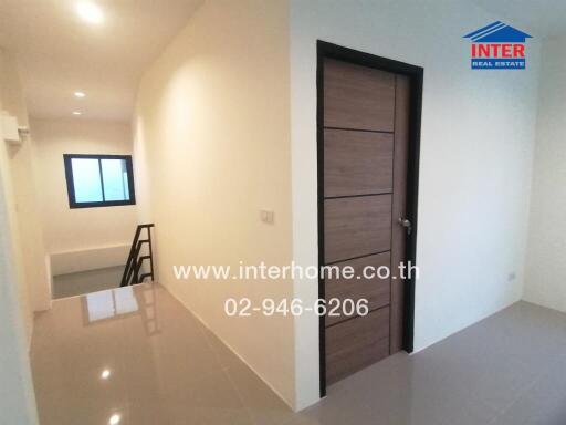 Spacious and well-lit empty bedroom with wooden door and tiled floor