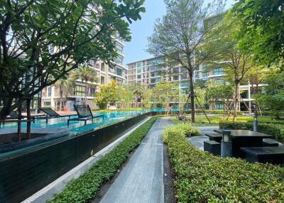 Modern residential building with lush garden and walking path