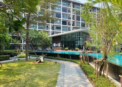 Modern residential building with lush garden and swimming pool