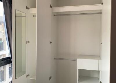 Spacious bedroom closet with built-in storage and mirror