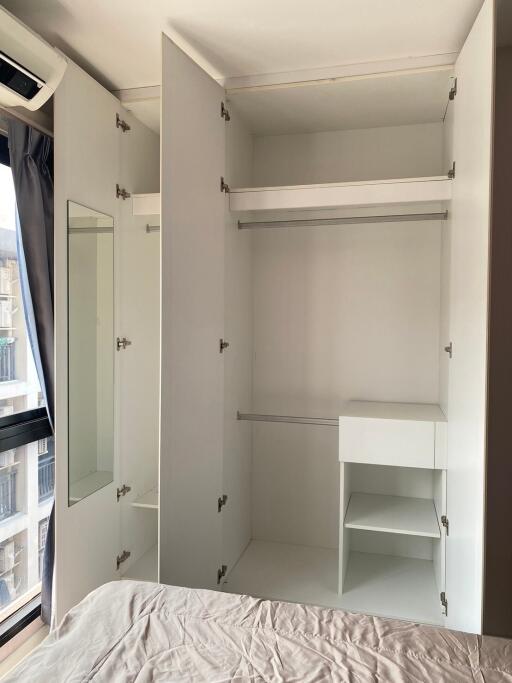 Spacious bedroom closet with built-in storage and mirror