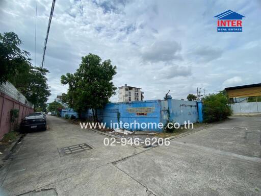Urban property lot with blue fencing and street view