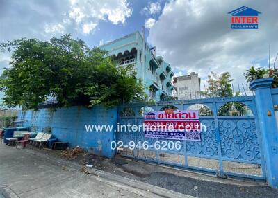 Blue residential building exterior with gated entrance