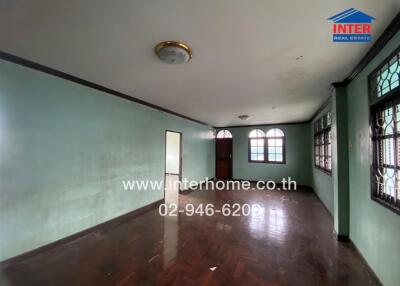 Spacious empty living room with wooden floor and green walls