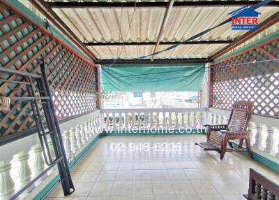 Spacious covered balcony with lattice privacy walls and outdoor seating