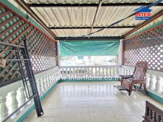 Spacious covered balcony with lattice privacy walls and outdoor seating