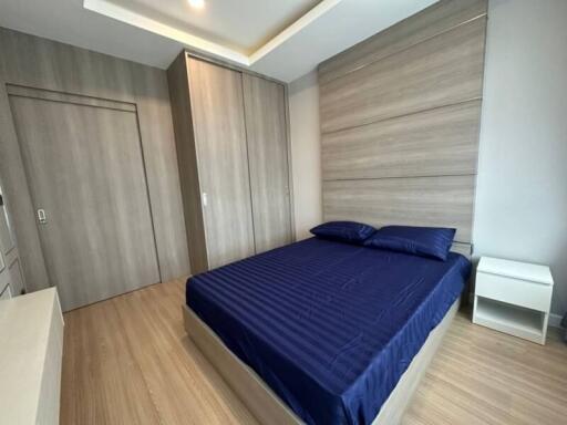 Modern bedroom with wooden accents and blue bedding