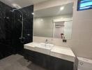 Modern bathroom with sleek design featuring marble countertops and black tiles