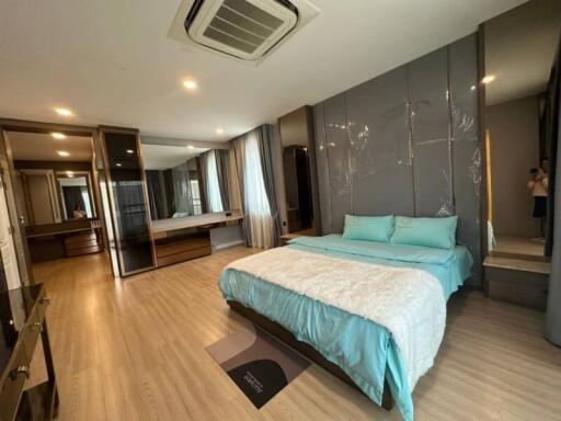 Spacious modern bedroom with large bed and mirrored wardrobe