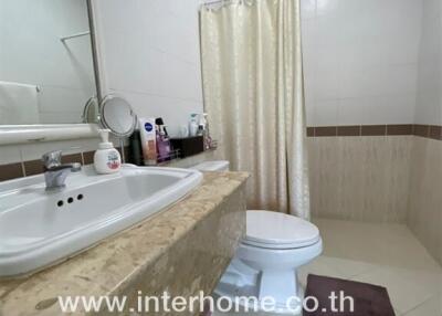 Modern bathroom with white fixtures and beige tiling