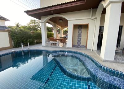 Elegant pool area with attached outdoor patio and seating
