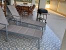 Spacious patio area with decorative tile flooring and outdoor furniture overlooking a scenic view