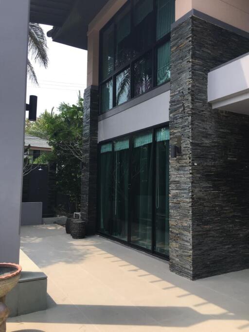 Modern residential building exterior with large glass windows and stylish stone cladding