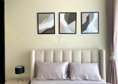Modern bedroom with minimalistic decor and abstract artwork