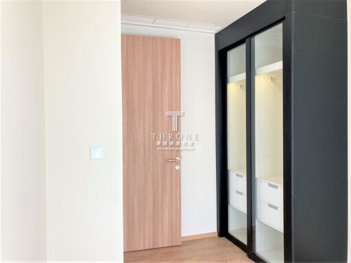 Modern bedroom entrance with wooden door and glass wardrobe