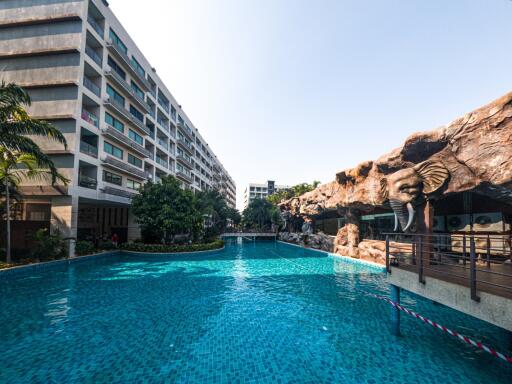 Luxurious residential building with a large outdoor swimming pool and rock-style decorations