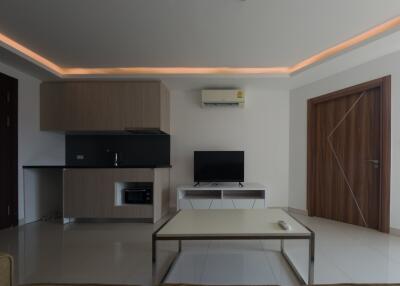 Modern living room with integrated kitchen, featuring contemporary furniture and ambient lighting